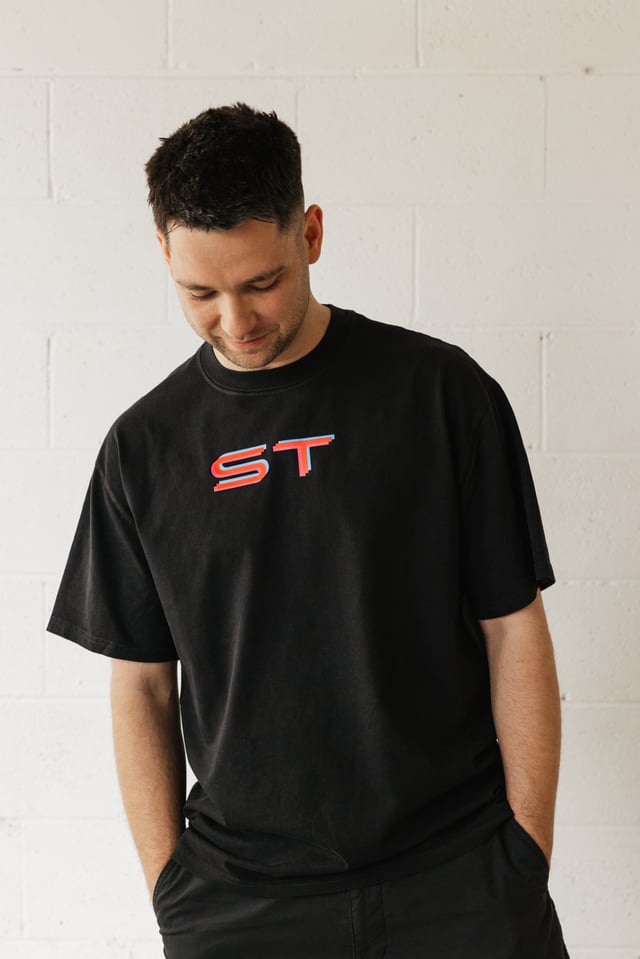 Man wearing the black Simply Techno tee with ST logo
